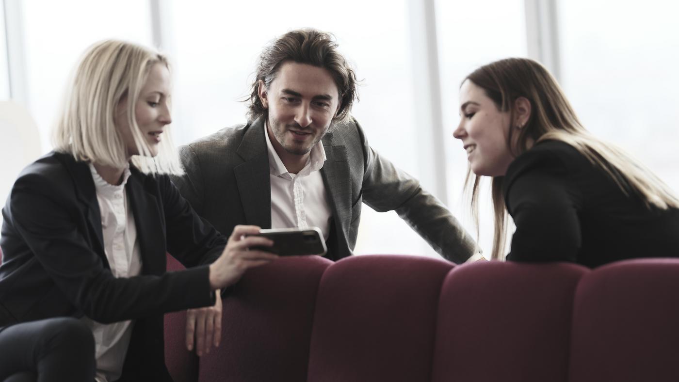 Kollegen schauen auf die Flossbach von Storch ONE App